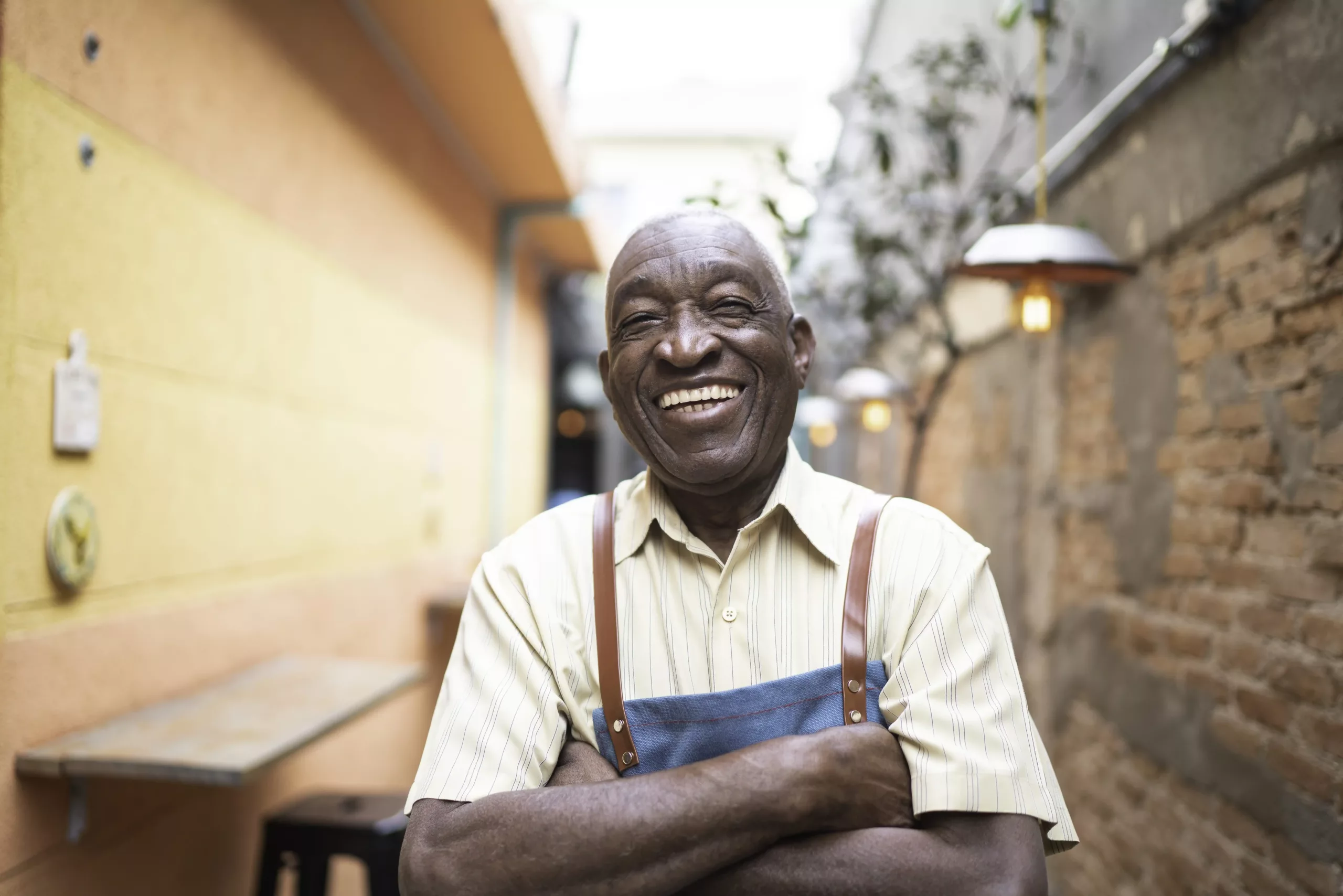 Portrait of smiling elderly waiter looking at camera