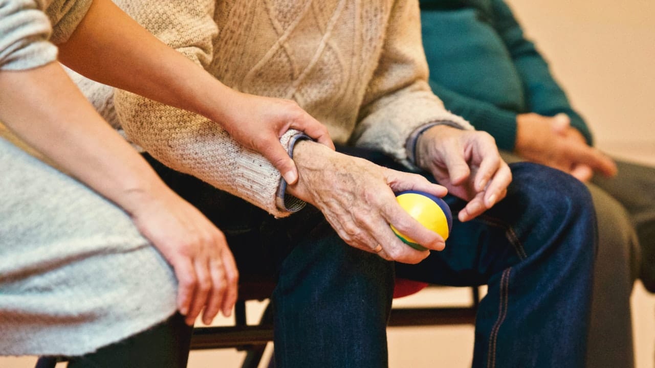 Person Holding a Stress Ball During Senior Rehab