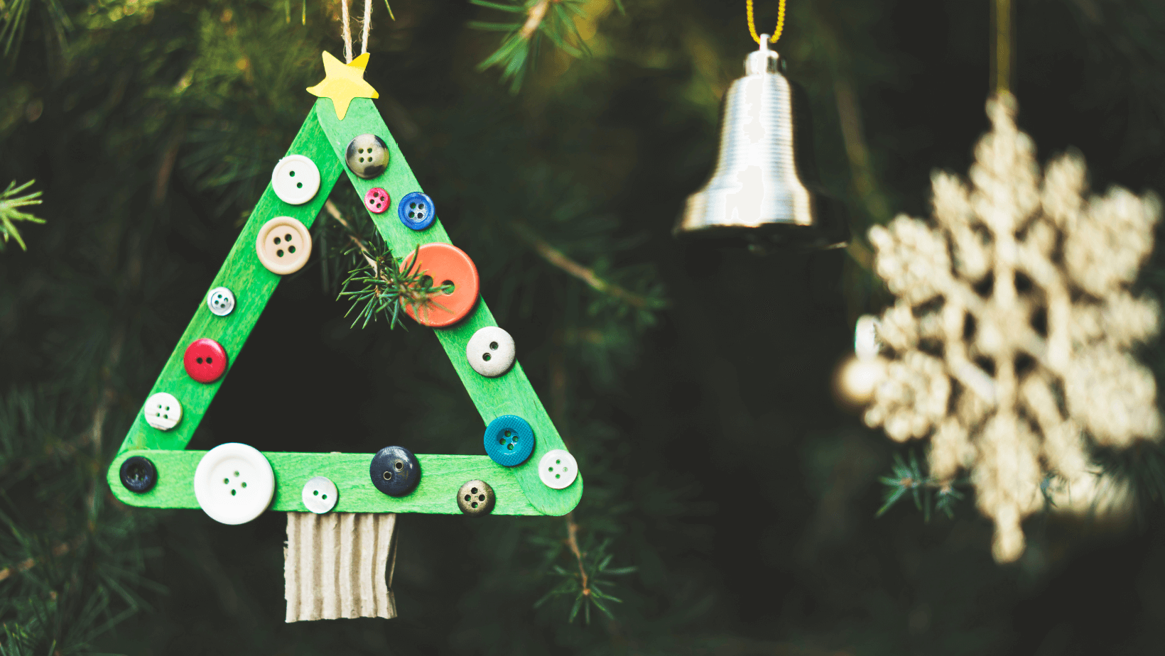 a green Christmas ornament hangs from a tree