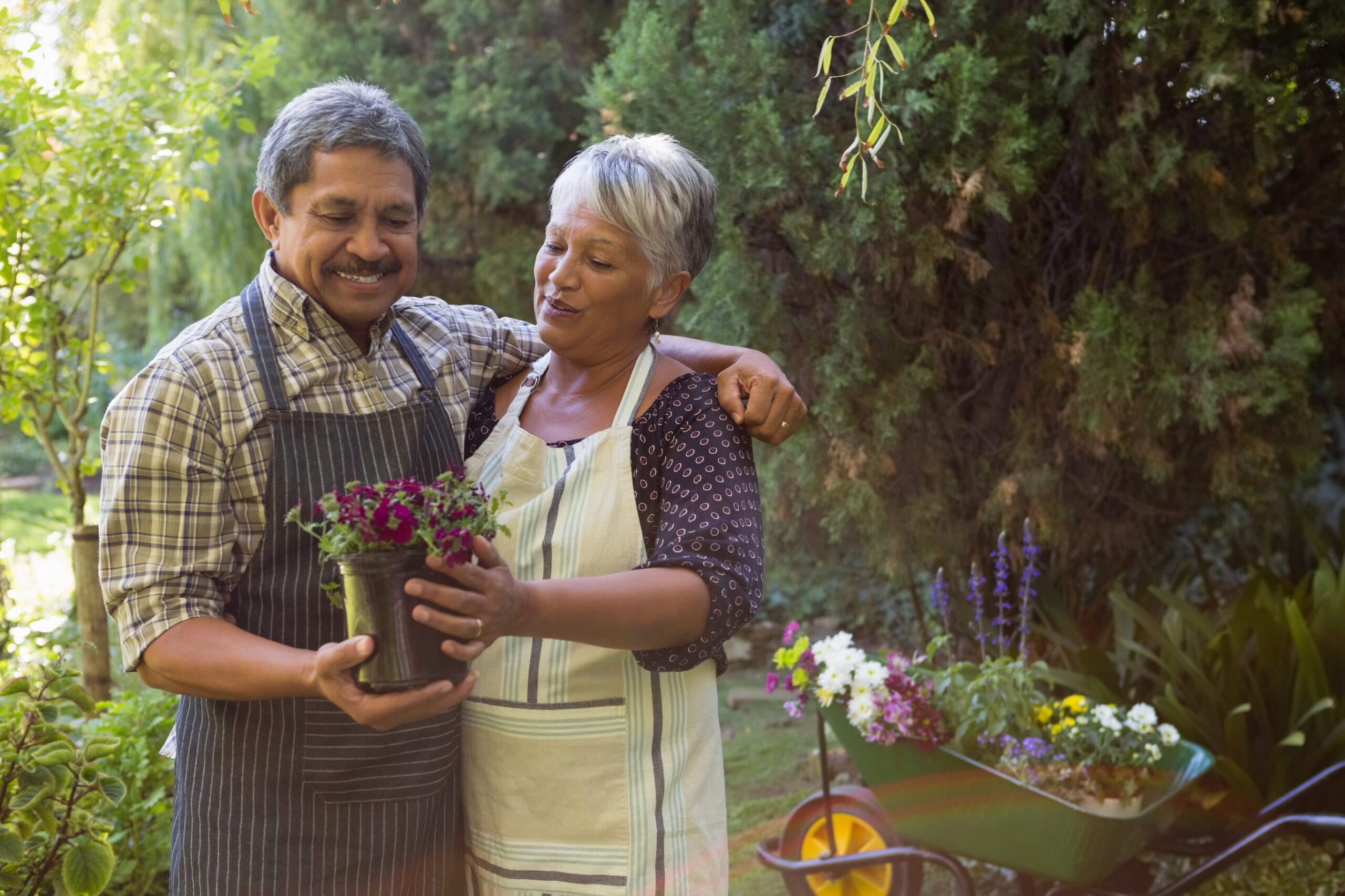 Elderly couple holding flowers in a garden