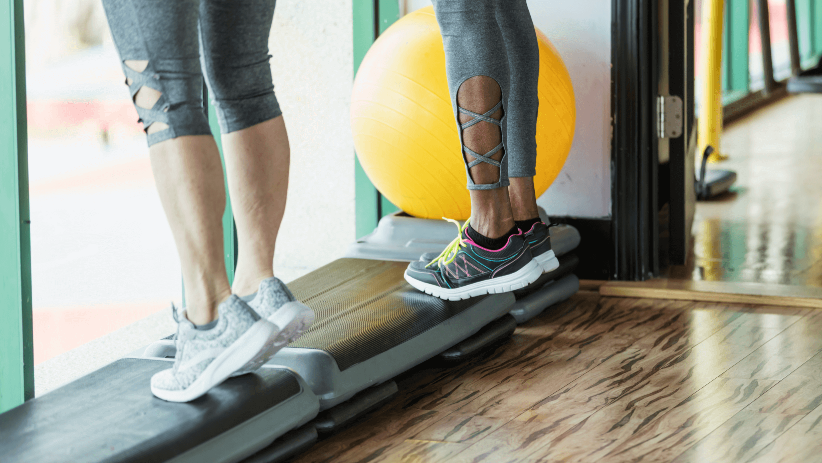 two people in a gym, doing calf raises