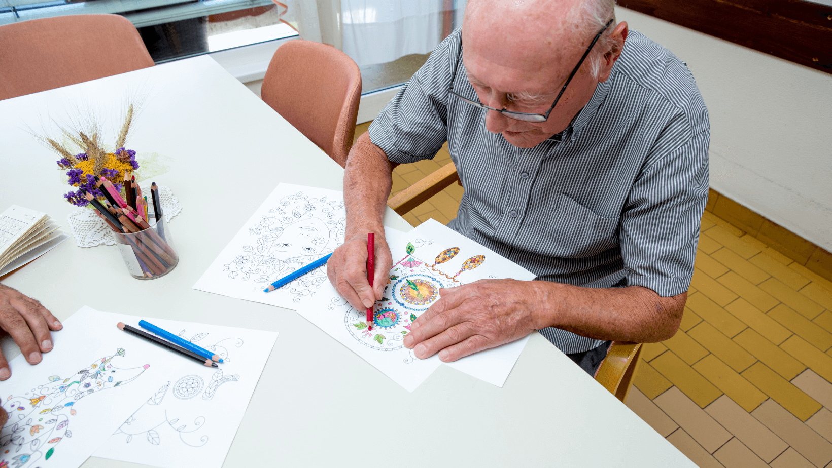 a senior man works on a coloring book