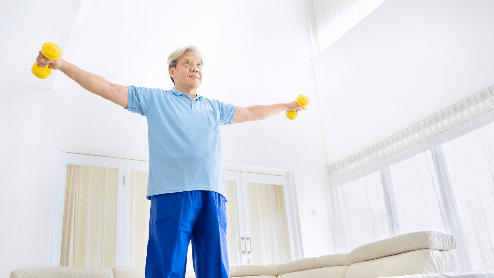 older man working out at home, doing lateral raises