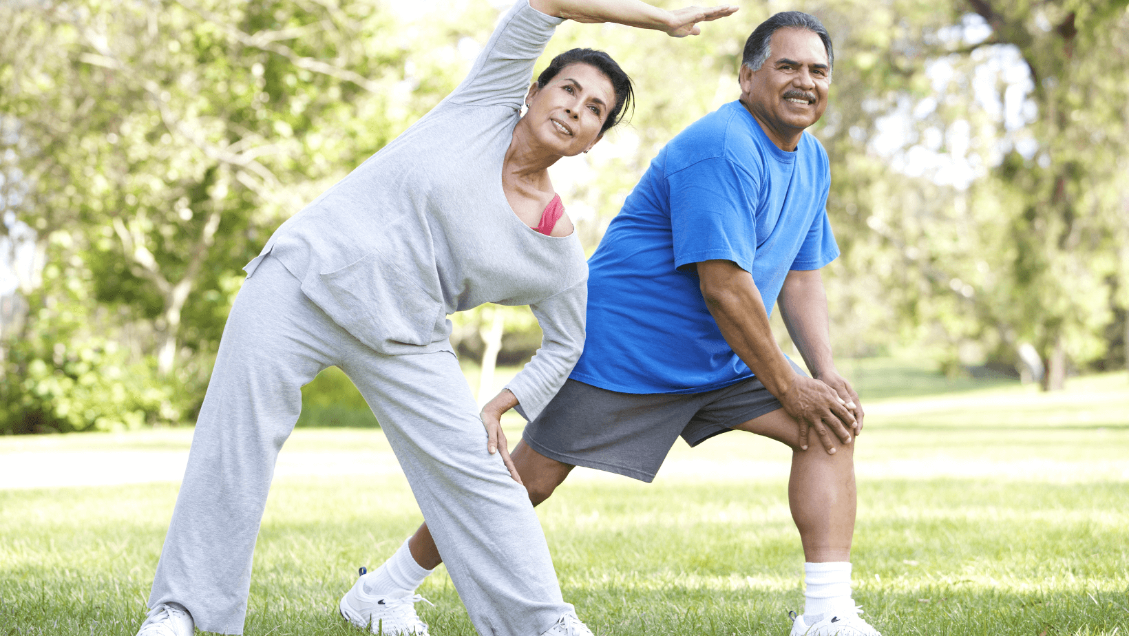 an older couple stretching together outside