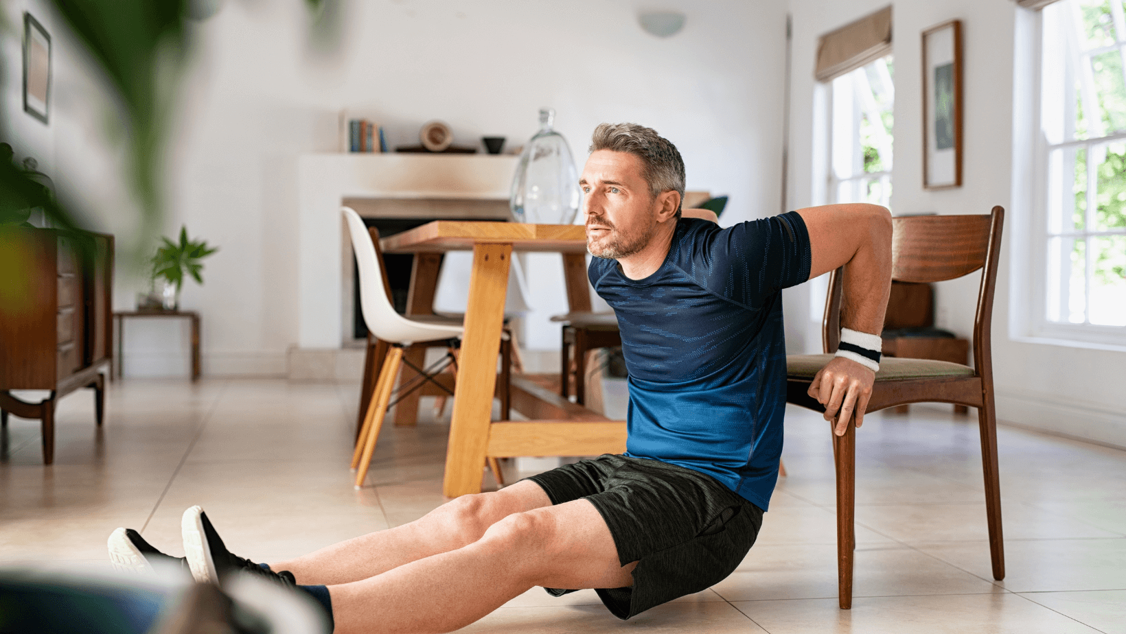 Older man doing tricep dips with chairs