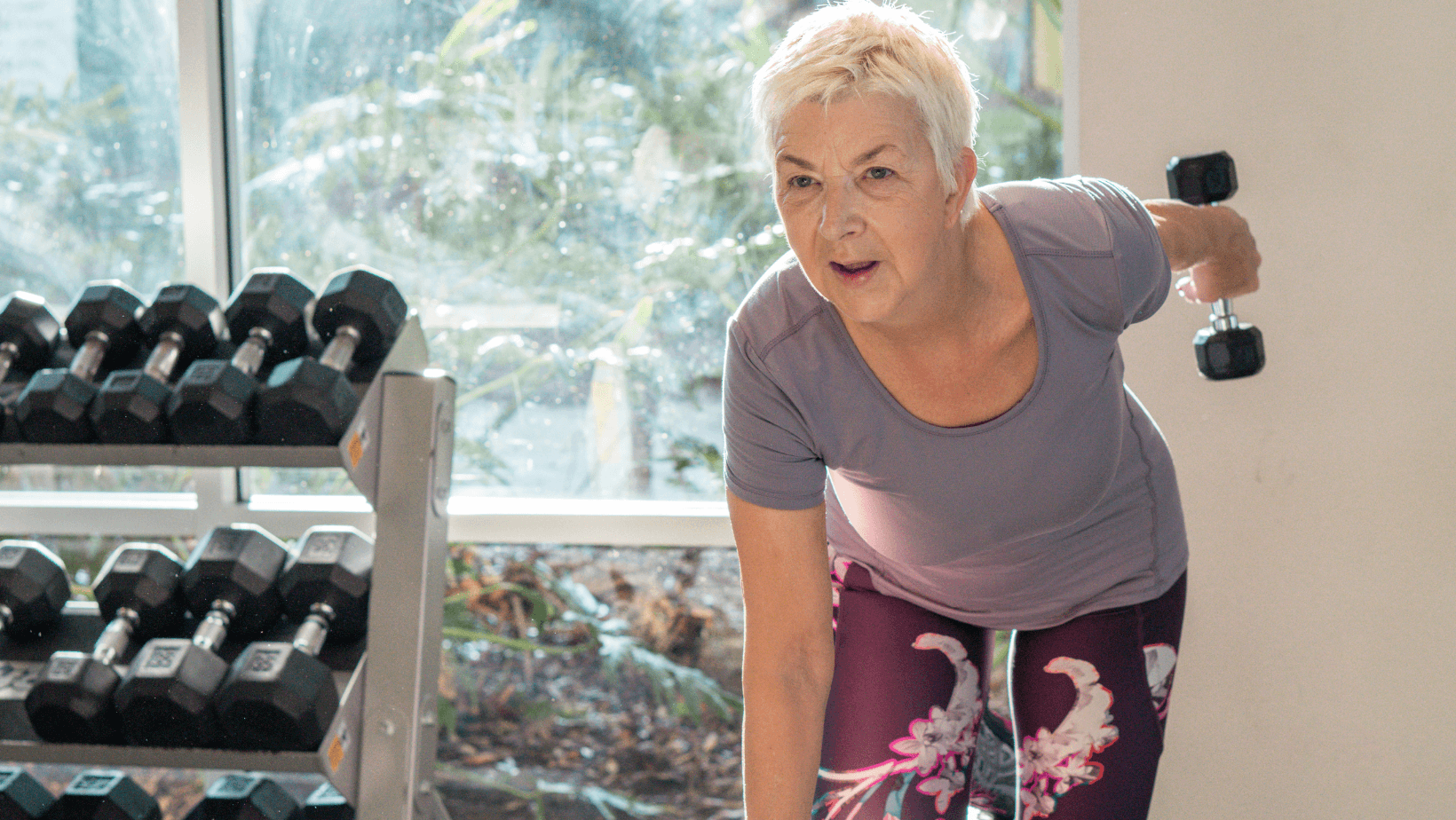 Older woman in a gym doing tricep extensions